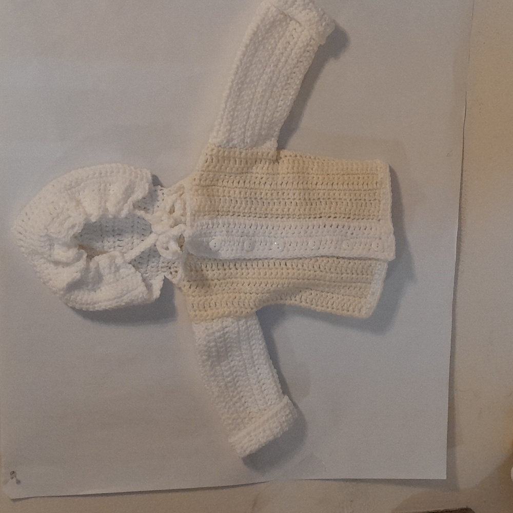 A light yellow and white baby hoodie.